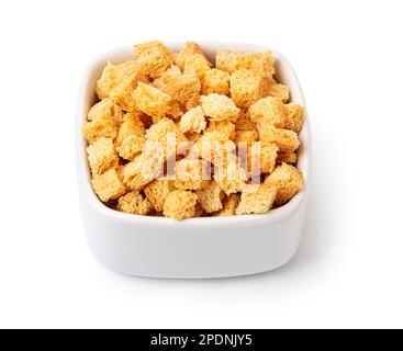 Crispy croutons in bowl isolated on white background with clipping path Stock Photo