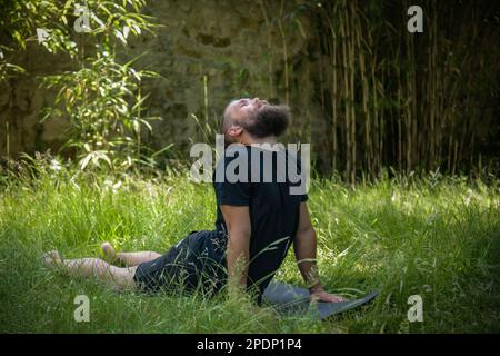 Caucasian man doing yoga in his garden in the morning Stock Photo
