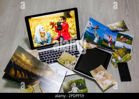 Old family photos on wooden background. Vintage pictures, notepad and modern notebook. Flat lay. Blank photo frames Stock Photo