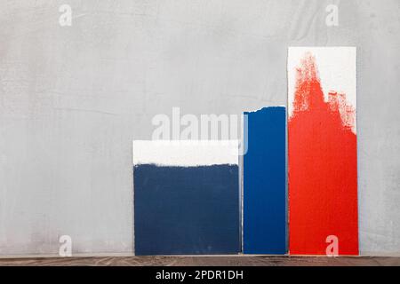 Red and blue color samplers at blank gypsum plaster wall. Choosing wall paint color during house renovation Stock Photo