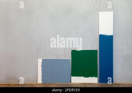 Grey green and blue color samplers at blank gypsum plaster wall. Choosing wall paint color during house renovation Stock Photo