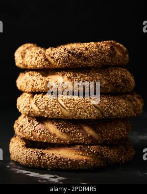 Close up ofTurkish simit bread pretzels stack. Homemade Sesame bagel on dark background. Low key, dark photo Stock Photo