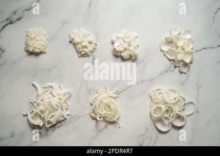 Different cuts of onions. Photo show different onion cuts from small to large dice, rings, chunks and half moon slice plus julienne Stock Photo