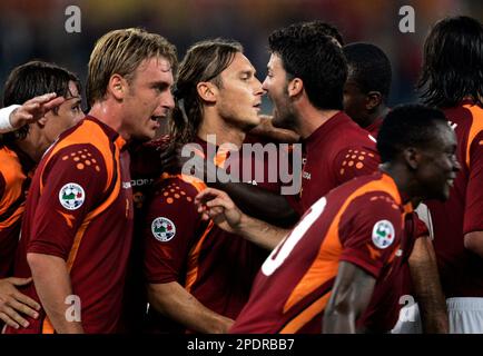 AS Roma's captain Francesco Totti, center with white jersey, sorrounded by  teammetes, holds the trophy with Italian President Giorgio Napolitano,  second from right, and Italian soccer league president Antonio Matarrese,  right, after