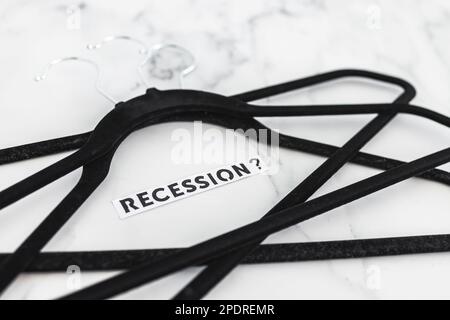 shopping and purchasing power in the post pandemic economy, group of clothes hangers with Recession text in the middle concept of buyers reducing thei Stock Photo