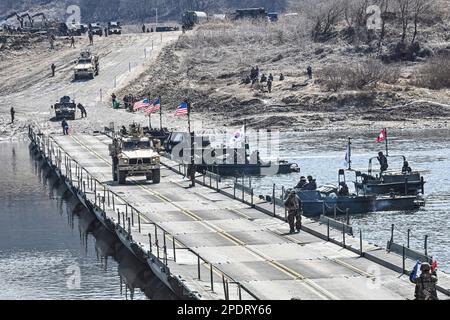 March 13, 2023, YEONCHEON, GYEONGGI, SOUTH KOREA: March 15, 2023-Yeoncheon, South Korea-Military vehicles cross a makeshift bridge assembled by South Korean and U.S. troops during combined river-crossing drills at a training ground in the border county of Yeoncheon, 62 kilometers of Seoul, in this photo provided by the South's Army on March 15, 2023. The drills kicked off on March 6 and will run until March 17. South Korea and the United States are conducting combined river-crossing military drills in a border county, the Army here said Wednesday, as part of the allies' ongoing springtime exer Stock Photo