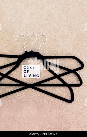 shopping and purchasing power in the post pandemic economy, group of clothes hangers with Cost of Living text in the middle concept of buyers reducing Stock Photo