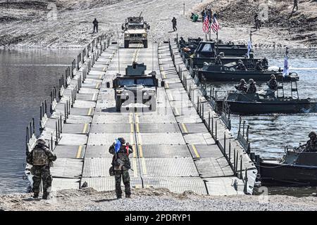 March 13, 2023, YEONCHEON, GYEONGGI, SOUTH KOREA: March 15, 2023-Yeoncheon, South Korea-Military vehicles cross a makeshift bridge assembled by South Korean and U.S. troops during combined river-crossing drills at a training ground in the border county of Yeoncheon, 62 kilometers of Seoul, in this photo provided by the South's Army on March 15, 2023. The drills kicked off on March 6 and will run until March 17. South Korea and the United States are conducting combined river-crossing military drills in a border county, the Army here said Wednesday, as part of the allies' ongoing springtime exer Stock Photo