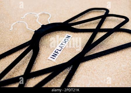 shopping and purchasing power in the post pandemic economy, group of clothes hangers with Inflation text in the middle concept of buyers reducing thei Stock Photo