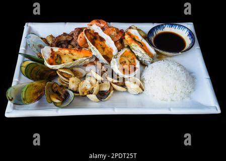 Sautéed seafood on white plate close up isolated on black background top view Stock Photo
