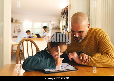 Multiracial father and son with Down syndrome using digital tablet Stock Photo