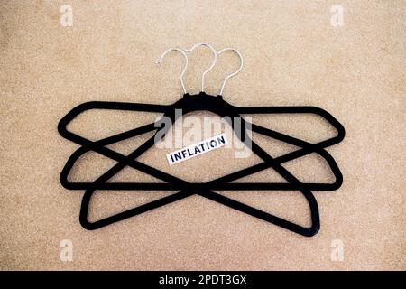 shopping and purchasing power in the post pandemic economy, group of clothes hangers with Inflation text in the middle concept of buyers reducing thei Stock Photo