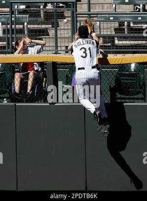 A fan reacts as Colorado Rockies center fielder Cory Sullivan runs up the wall to try and catch a solo home run hit by Arizona Diamondbacks' Troy Glaus during the fourth inning at Coors Field in Denver, Sunday, Sept. 11, 2005. (AP Photo/Jack Dempsey)