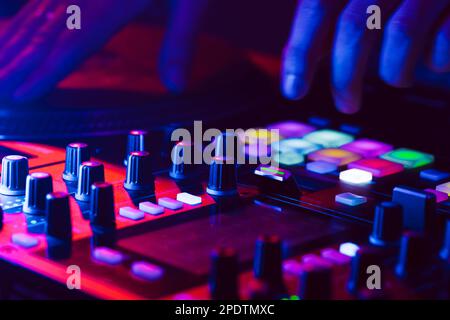 Hands of a DJ creating and regulating music on dj console mixer at club concert Stock Photo