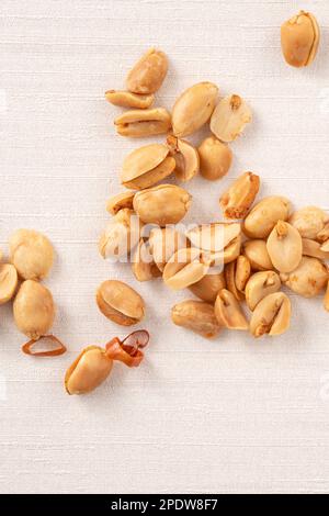 Spicy flavored peanut kernel spilling on white table background. Stock Photo