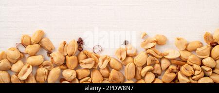 Spicy flavored peanut kernel spilling on white table background. Stock Photo