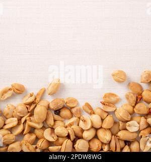 Spicy flavored peanut kernel spilling on white table background. Stock Photo