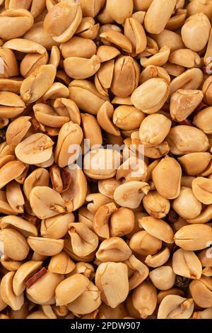 Spicy flavored peanut kernel spilling on white table background. Stock Photo