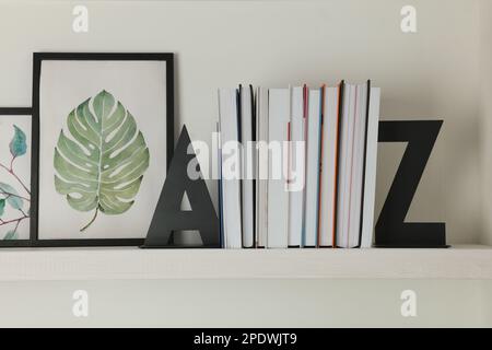 Bookends with books and pictures on shelf indoors Stock Photo