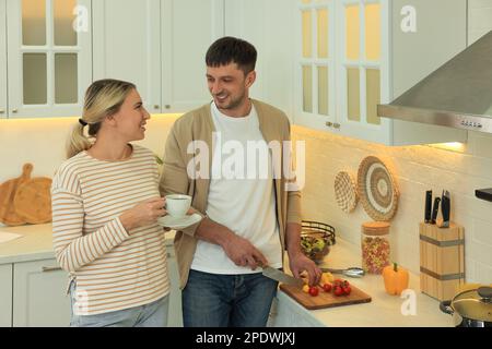 Happy couple spending time together while preparing food in kitchen Stock Photo