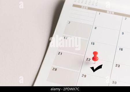 Red pin and arrow symbol on calendar. Confirmation of appointment or meeting concept. Stock Photo