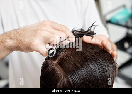 Barber talking to caucasian man while sitting in chair Stock Photo