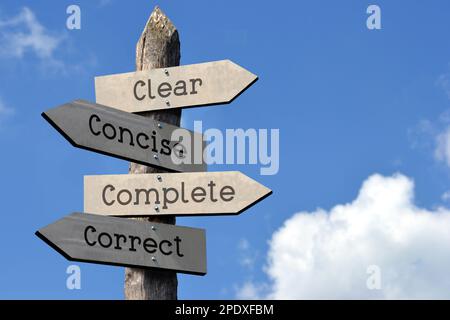 Omplete Clear, concise, complete, correct - wooden signpost with four arrows ...