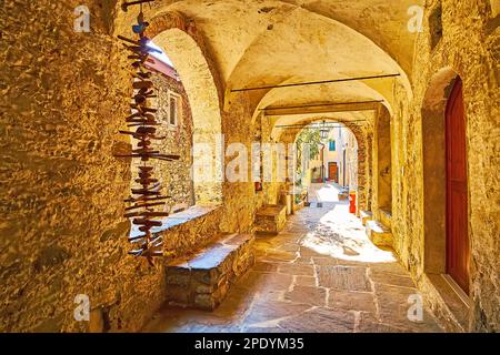 The covered vintage alleyway with rib-vaulted ceiling, arched windows, providing daylight and decoration of small wood pieces, Gandria, Ticino, Switze Stock Photo