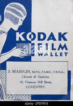 Vintage paper Kodak film wallet with illustration of a 1920s styled woman with shingled hair using an early camera. Stock Photo