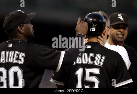 Chicago White Sox first base coach Tim Raines, left, examines a