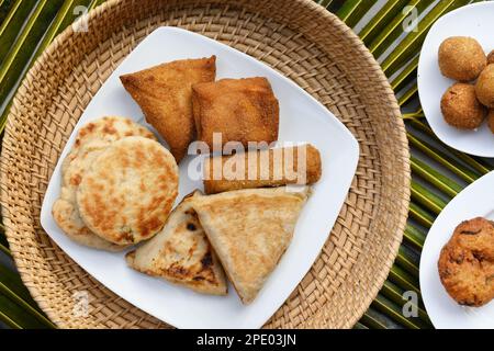 Authentic Sri Lankan different street food, short eats. Vegetable roti, coconut roti, cutlets, mutton rolls on white plate. Snacks made with tuna, pot Stock Photo