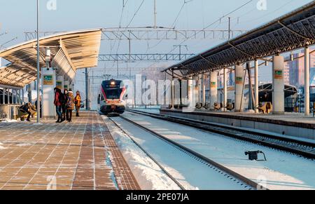 Minsk, Belarus - January 22, 2018: Arrival of an electric train to the station. Train, people, platform, winter, day Stock Photo