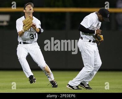 Colorado Rockies center fielder Cory Sullivan, left, pulls in a fly ball off the bat of New York Mets' Miguel Cairo as Rockies shortstop Desi Relaford attempts to stay out of the way in the eighth inning of the Mets' 9-3 victory in Denver on Wednesday, July 27, 2005. (AP Photo/David Zalubowski)