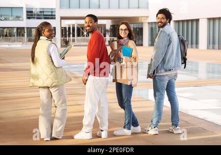 Glad young multiracial people students in casual with headphones, notebooks and coffee, study communicate Stock Photo
