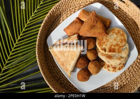 Authentic Sri Lankan different street food, short eats. Vegetable roti, coconut roti, cutlets, mutton rolls on white plate. View from above. Copy spac Stock Photo