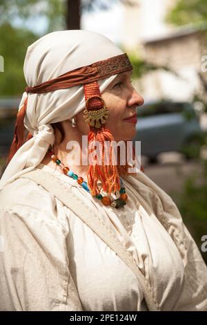 Khabarovsk, Russia - June 11, 2017: Middle ages period costume - senior Caucasian woman dressed in simple white dress. Poor lady peasant white canvas Stock Photo