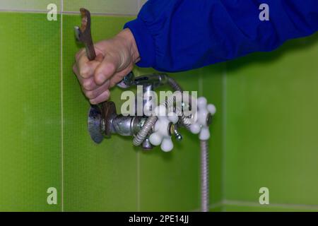 Man unscrew the mixer in the bathroom Stock Photo