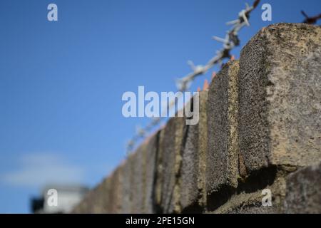 Barbed Wire ontop of Brick wall Stock Photo