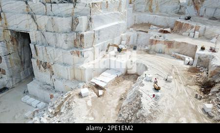 Heavy machines working at a huge marble quarry in Europe. Transporting the marble blocks. Stock Photo