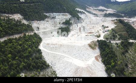 Heavy machines working at a huge marble quarry in Europe. Transporting the marble blocks. Stock Photo