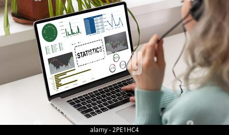 Female Analyst at Her Desk Works on a Laptop Showing Statistics, Graphs and Charts. She Works on the Wooden Table in Creative Office. Over the Stock Photo