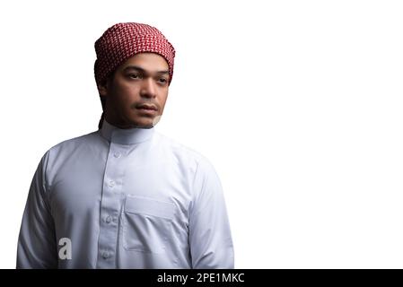 A Muslim male in a traditional headdress and outfit posing on a white background Stock Photo