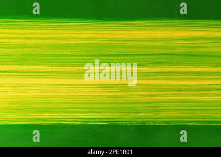 Beautiful green paint brush on yellow background. Abstract art background, Oil paint on cement table, Green and yellow texture, Fragment of art,  Brus Stock Photo