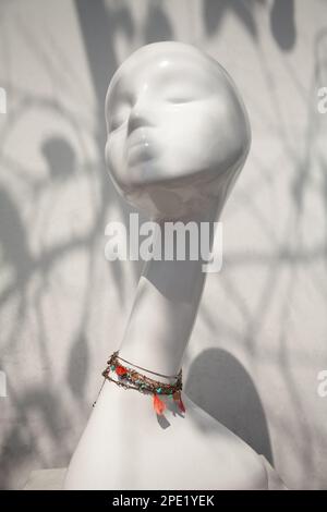 Necklace on a female mannequin displayed in a store window. Elegant lady mannequin wearing fashion accessories Stock Photo