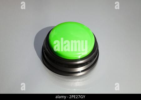 Big green buzzer for answers in a game show isolated on gray. Wireless button for teaching kids or training animals Stock Photo