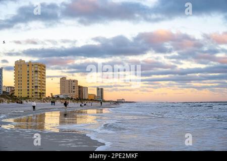 People along the shoreline of Jacksonville Beach, Florida, enjoying the beauty and serenity of a colorful ocean sunrise. (USA) Stock Photo