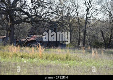 An old abandoned building on a cattle farm in Missouri, MO, United States, US, USA, is slowing falling down as it surrenders to time and the elements. Stock Photo