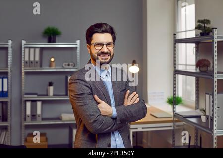 Handsome confident businessman posing with arms crossed in office Stock Photo