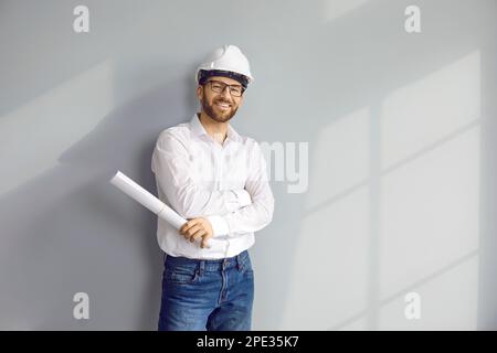 Portrait of happy architect or construction engineer in white shirt, safety hat, and glasses Stock Photo