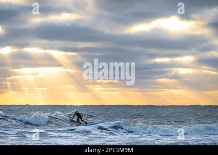 Surfer catching waves on an early morning in winter at Jacksonville Beach, Florida. (USA) Stock Photo